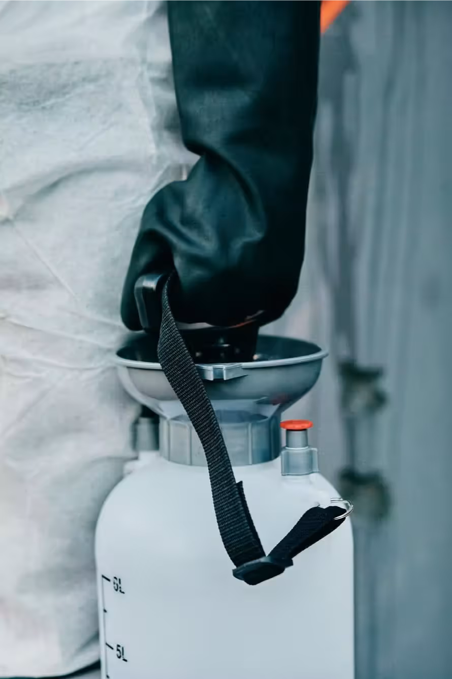 Black safety glove carrying a chemical container